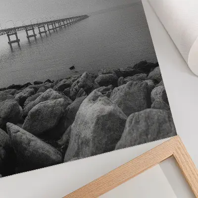 Plakát na zeď klidná krajina s mostem u skalnaté pláže pod šedou oblohou