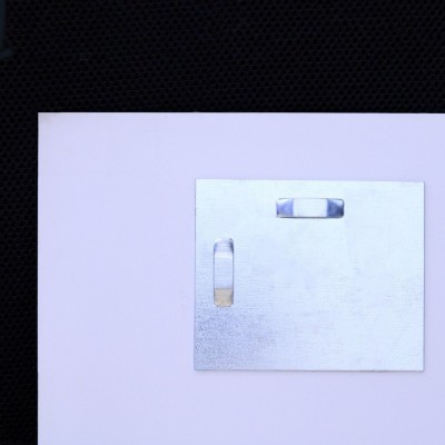 Obrázek je připevněn dvěma závěsy. Na fotografii jsou závěsy přilepeny na dvou místech